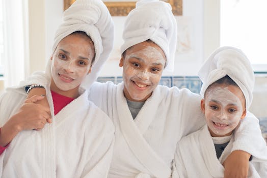 Mother and daughters smiling in bathrobes and face masks enjoying a home spa day.