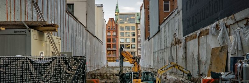 Construction site in an urban area with excavators and scaffolding, showcasing development.