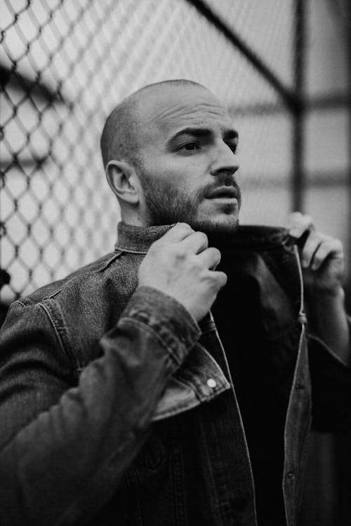 Grayscale Photo of a Man Wearing Denim Jacket