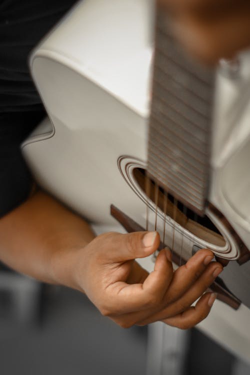 A Person Holding White Acoustic Guitar