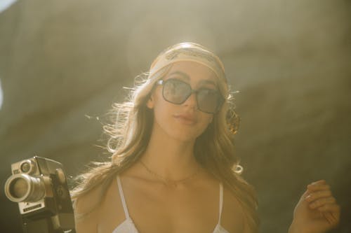 Woman Wearing Sunglasses Holding a Video Camera