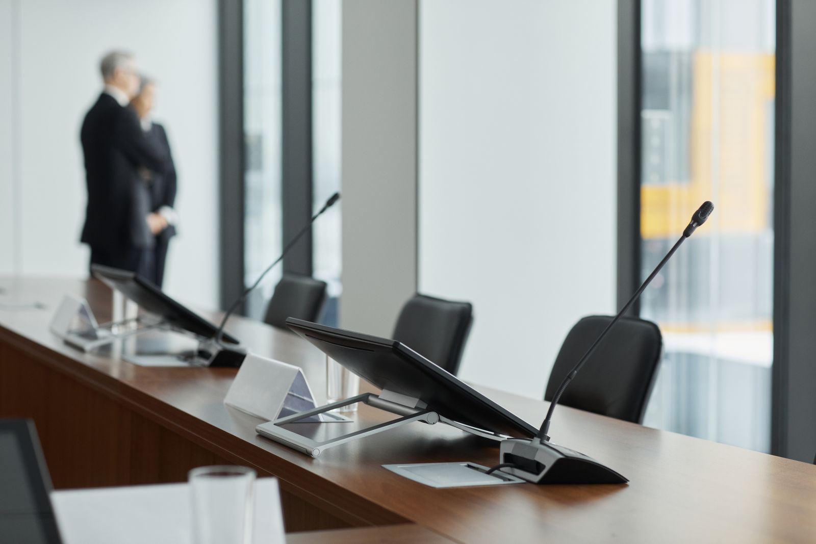 Conference room table with microphones and monitors for corporate AV support