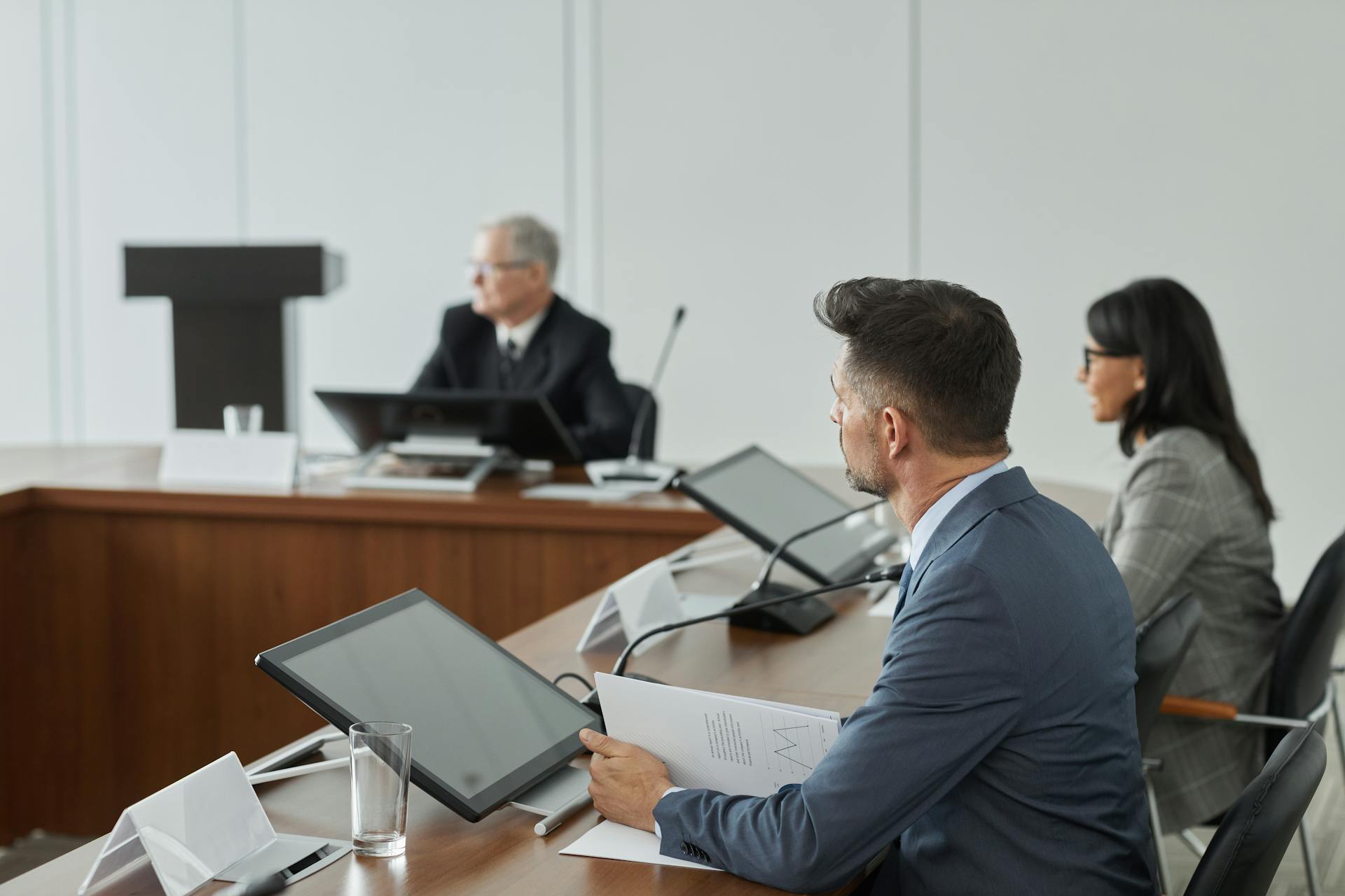 Business professionals having a meeting in a modern conference room with digital devices.