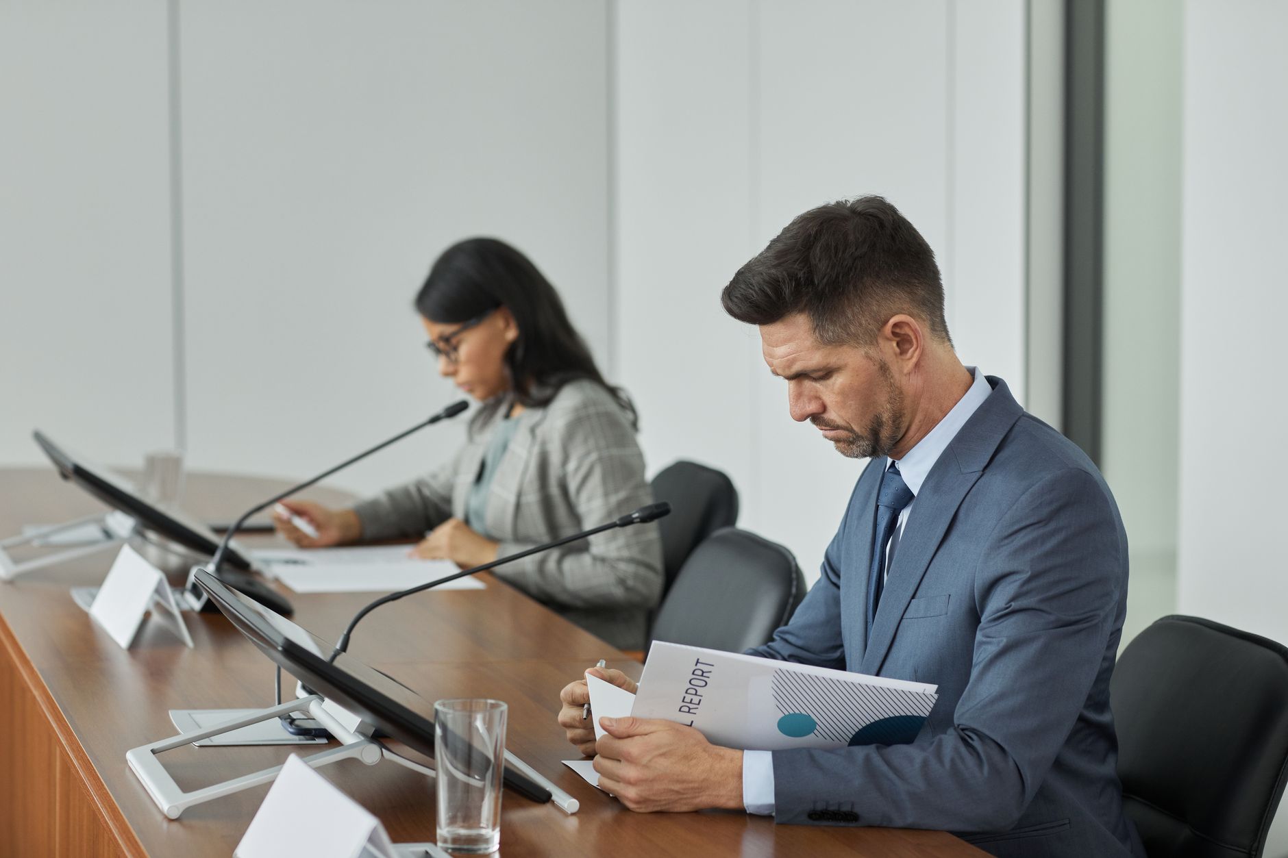 Business professionals reviewing compliance documents during a board meeting