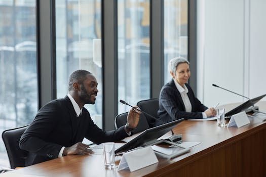 Two professionals speaking at a business conference in a modern office setting.