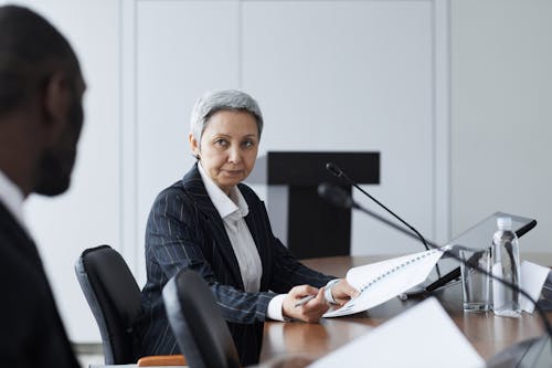 Professional Woman Seated in front of Conference Table