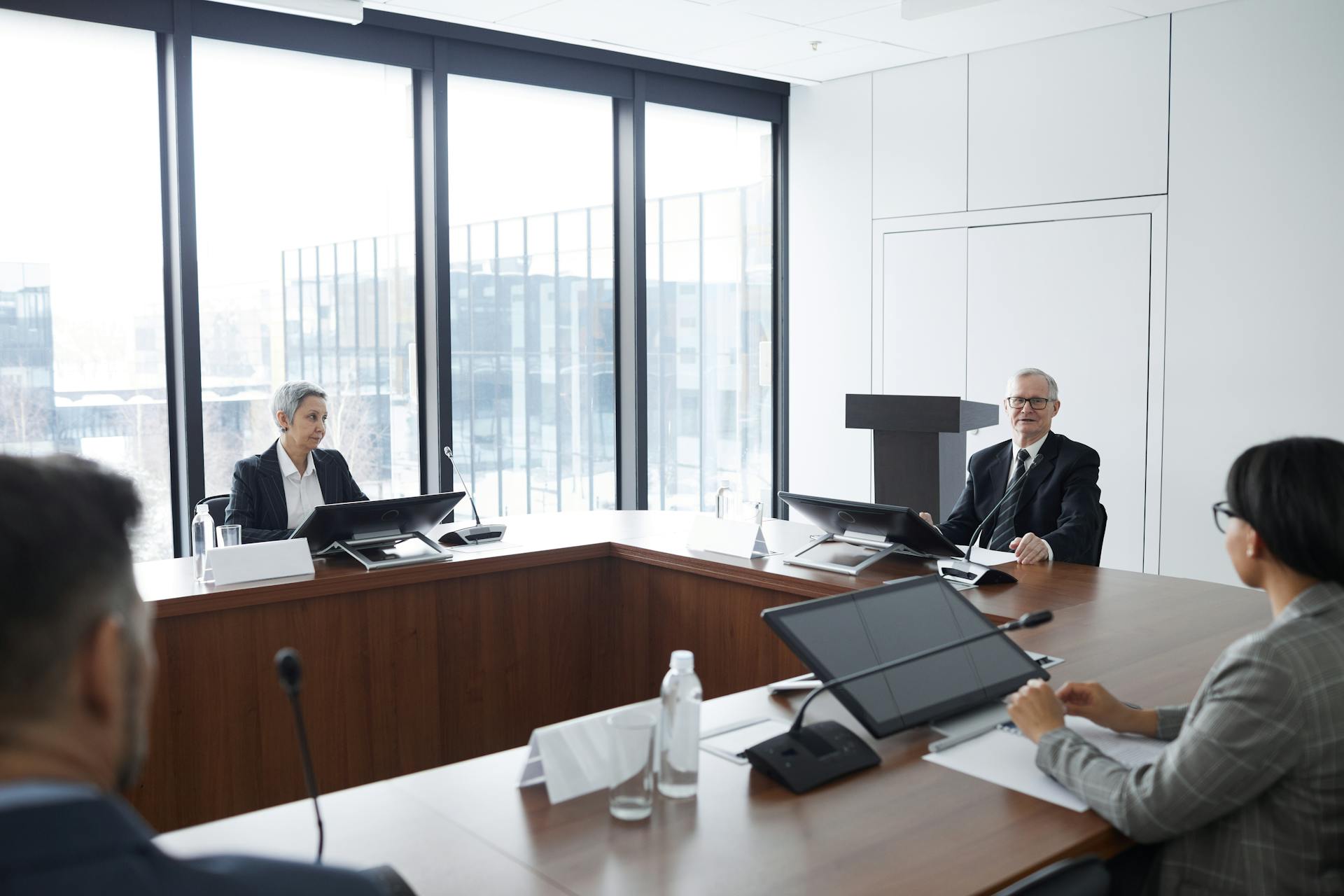 Business professionals in a board meeting in a modern conference room, engaging in discussion.