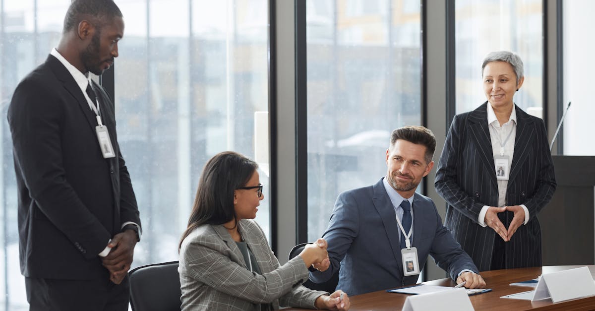 A diverse group of professionals shaking hands during a business meeting in a modern office.