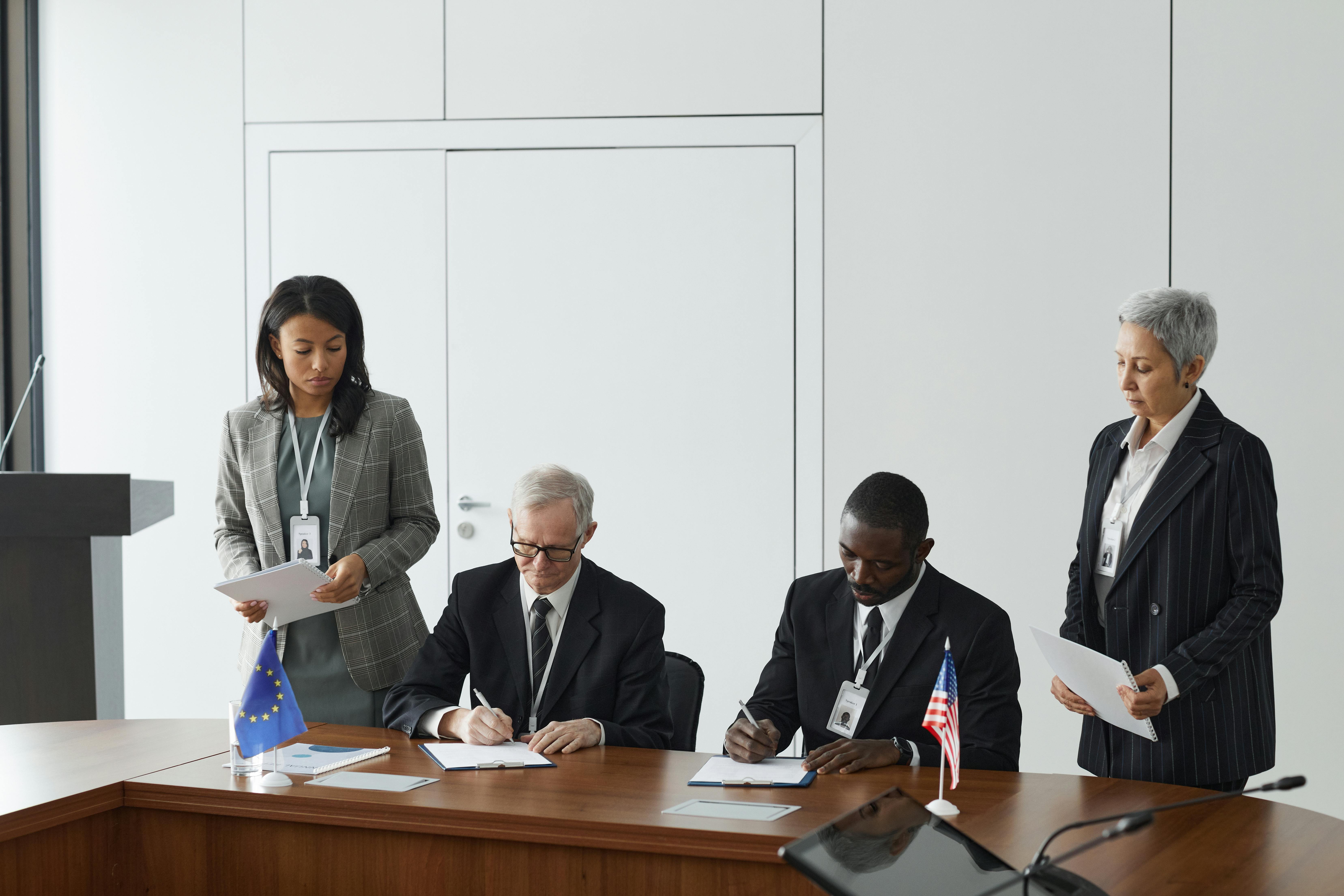 Business leaders signing a significant agreement in a conference room setting.