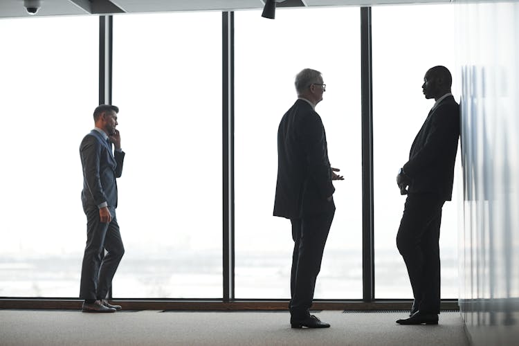 Men Standing Beside Glass Window