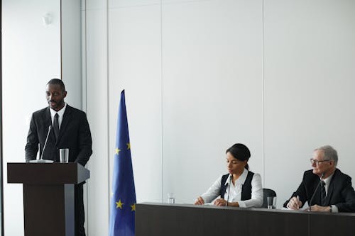 Man Standing at a Rostrum and Talking at a Political Conference 