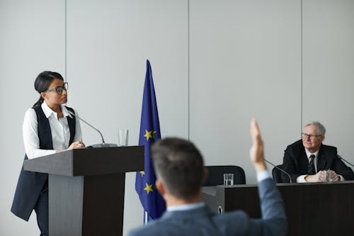 Woman Standing at a Rostrum and Talking during a Political Conference 