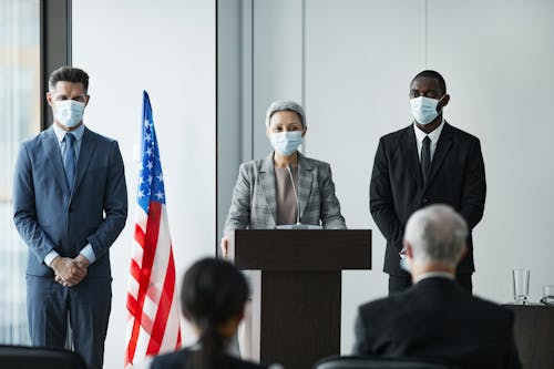 Men and Women in Masks at Conference