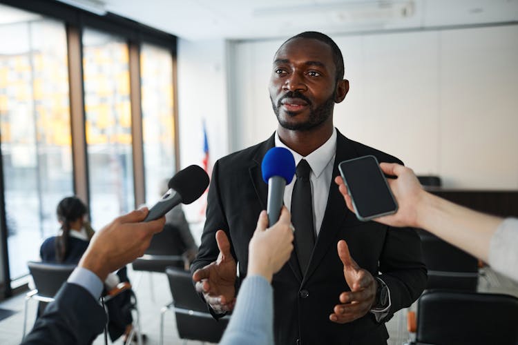 A Man In Black Suit Having An Interview