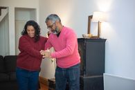 Man in Red Long Sleeve Shirt and Blue Denim Jeans Standing Beside Woman in Blue Denim