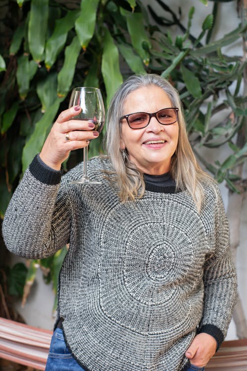 Woman Wearing a Sweater Holding a Glass of Wine