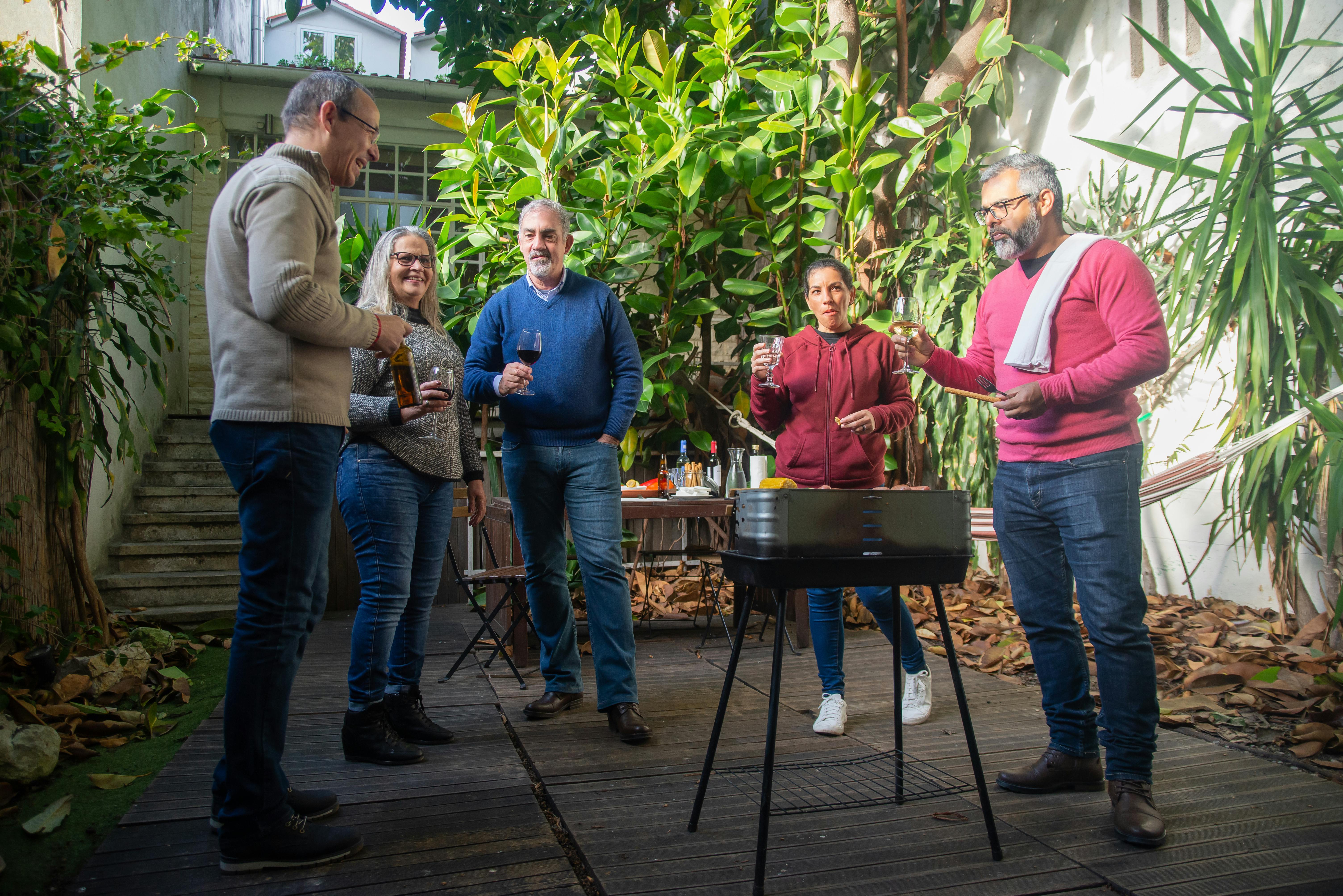 friends standing around a barbecue grill