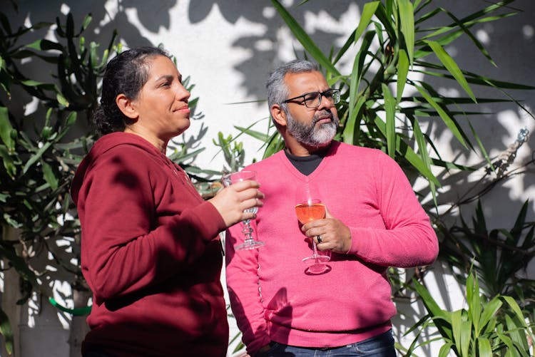 Photo Of A Man And A Woman Holding Glasses