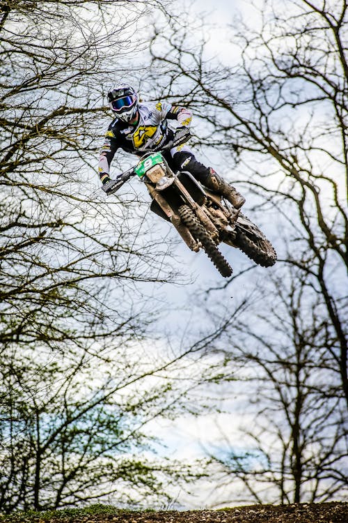 Hombre En Traje De Moto Blanco Y Negro Montando Motocross Dirt Bike · Foto  de stock gratuita