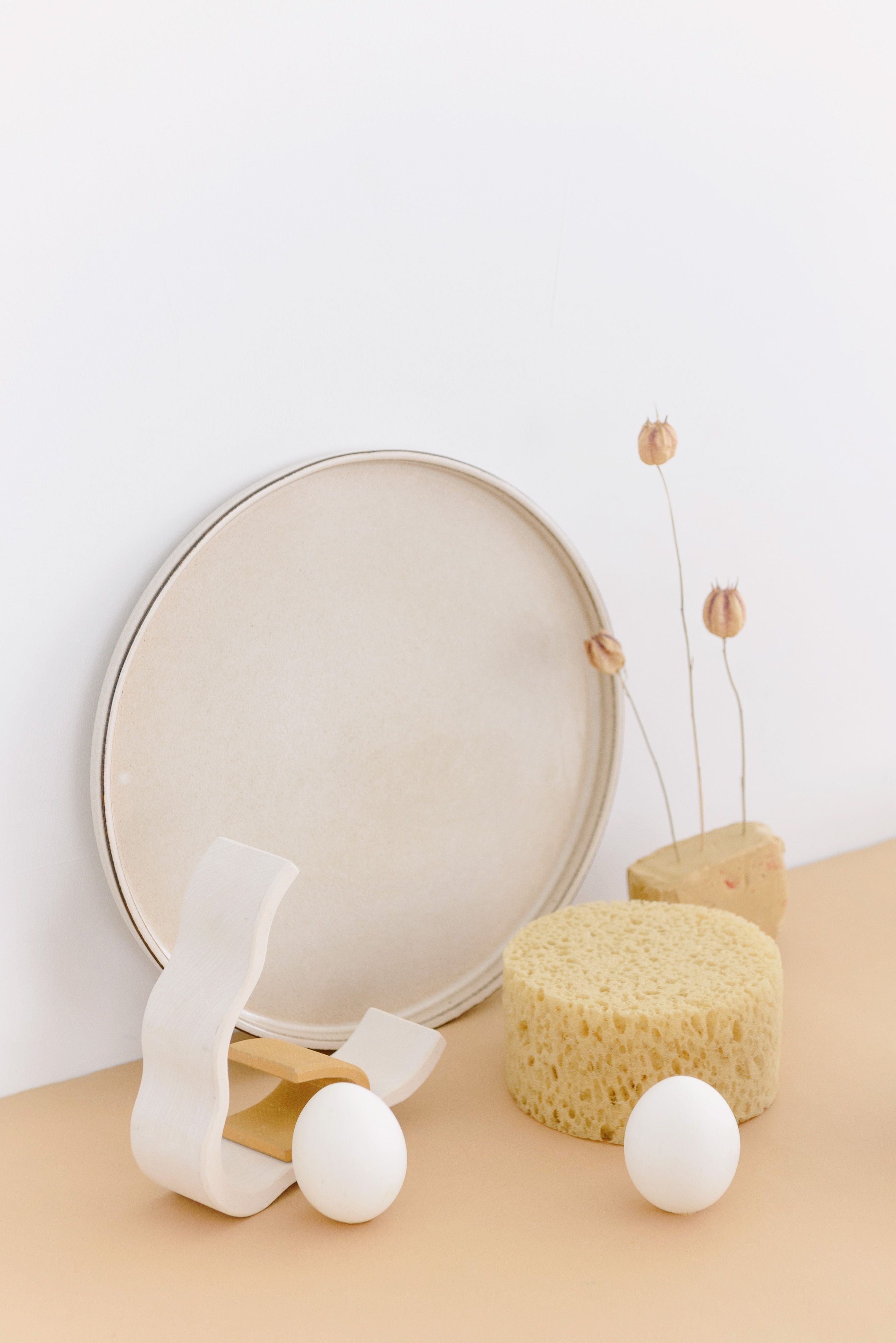 A minimalistic composition featuring geometric shapes and natural textures against a white background.