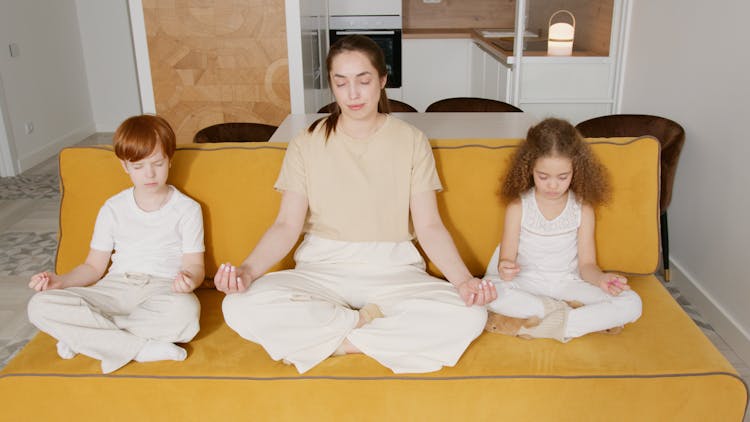 
A Woman Meditating With Her Children