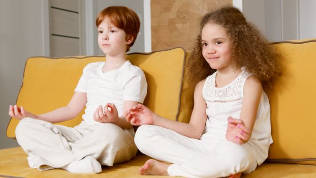 Two children practicing meditation indoors, promoting peace and calmness.