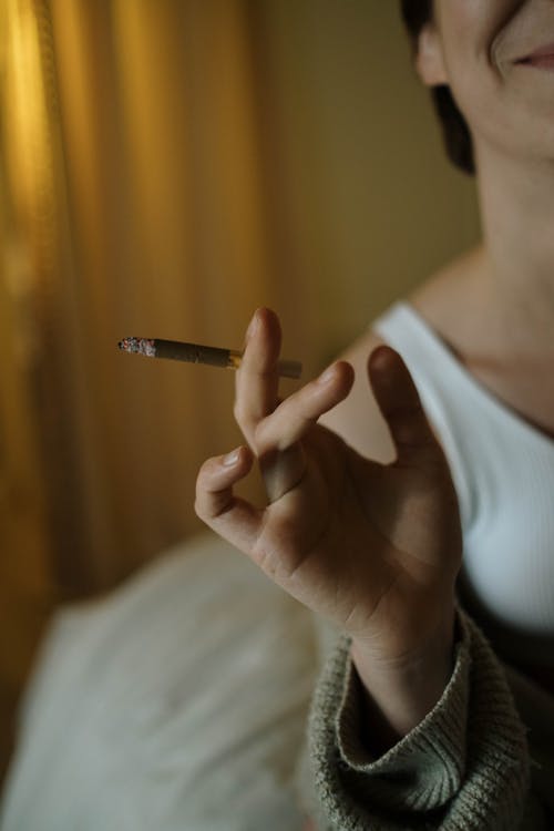Free Photo of a Person's Hand Holding a Brown Cigarette Stock Photo