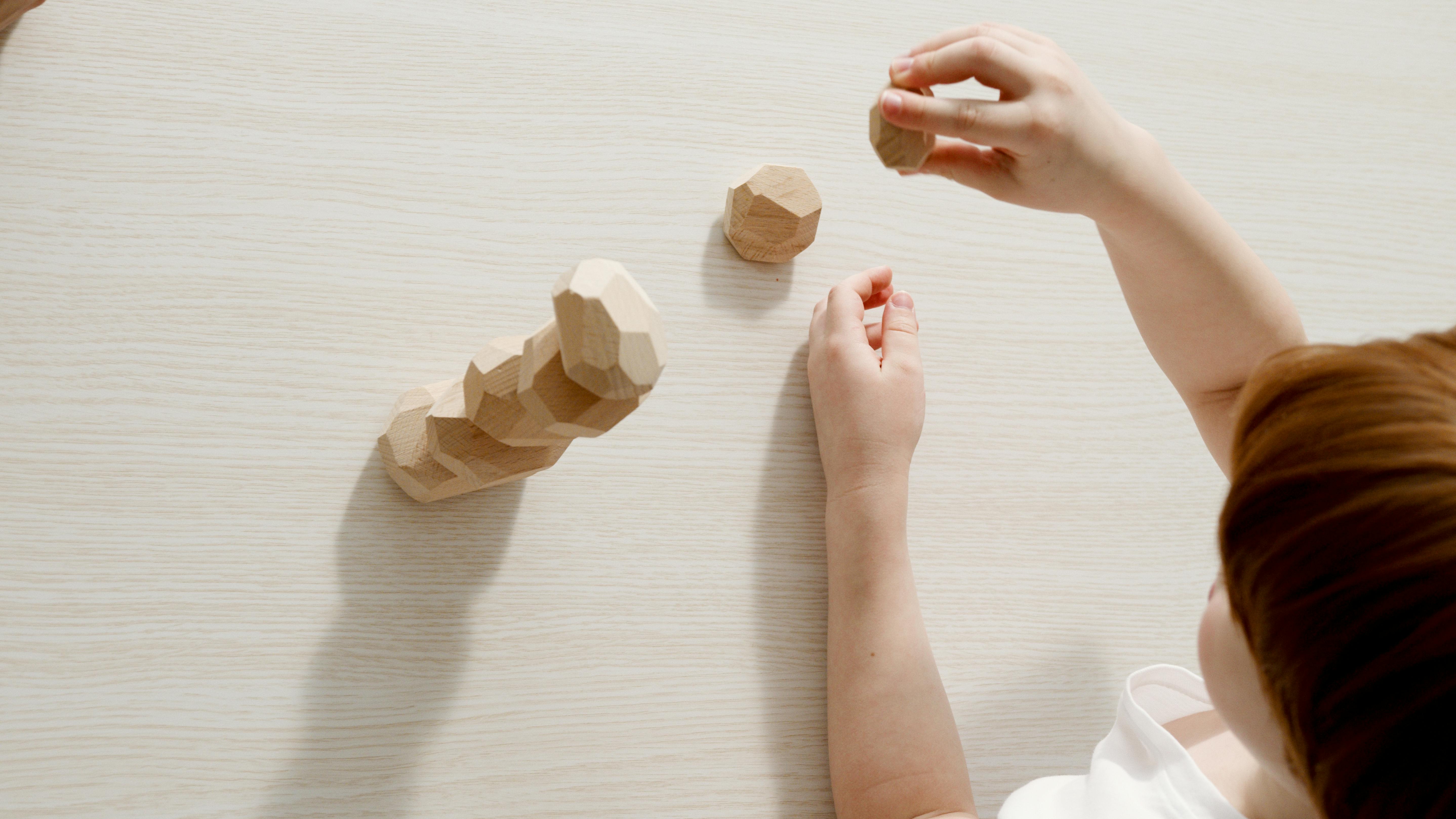 a kid playing wooden toys