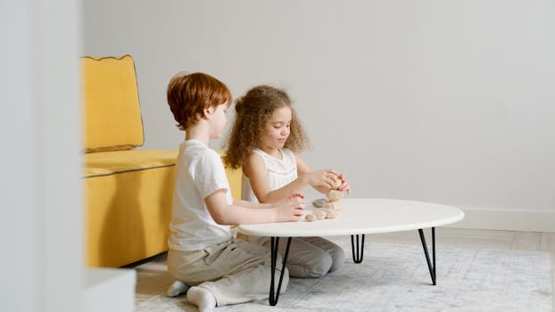 Two children playing with wooden blocks indoors, fostering creativity and fun.