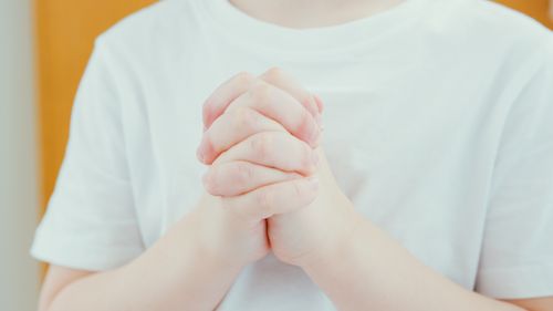 Free A child's hands folded in prayer, highlighting innocence and spirituality. Stock Photo