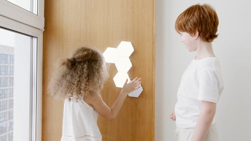 Photo of Siblings Playing with Lights Together