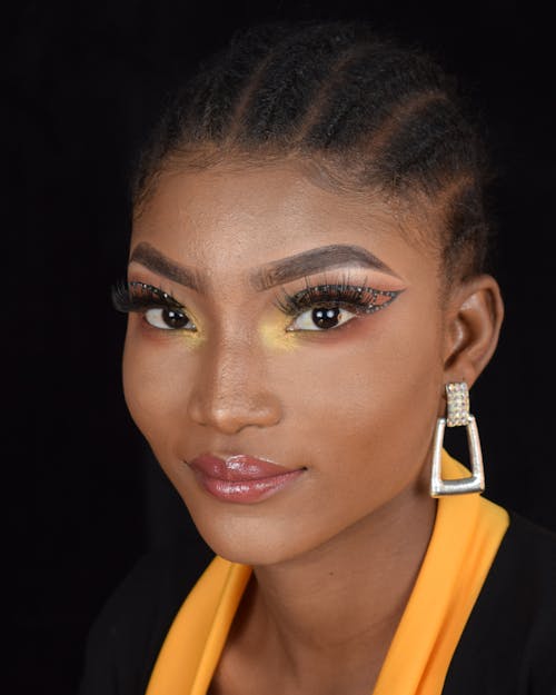 Stylish black woman looking at camera against black background