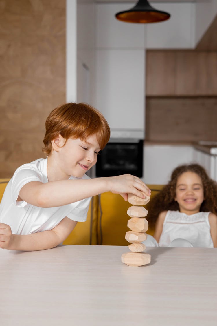 A Boy Stacking Wooden Stones