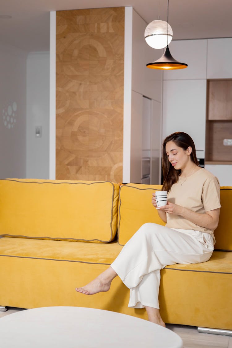 A Woman Sitting On Yellow Sofa