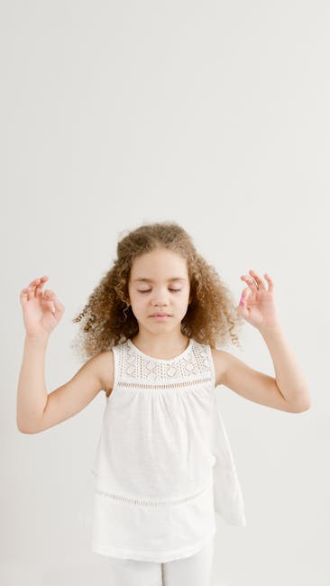 Portrait of a young girl meditating with eyes closed in a serene studio environment.