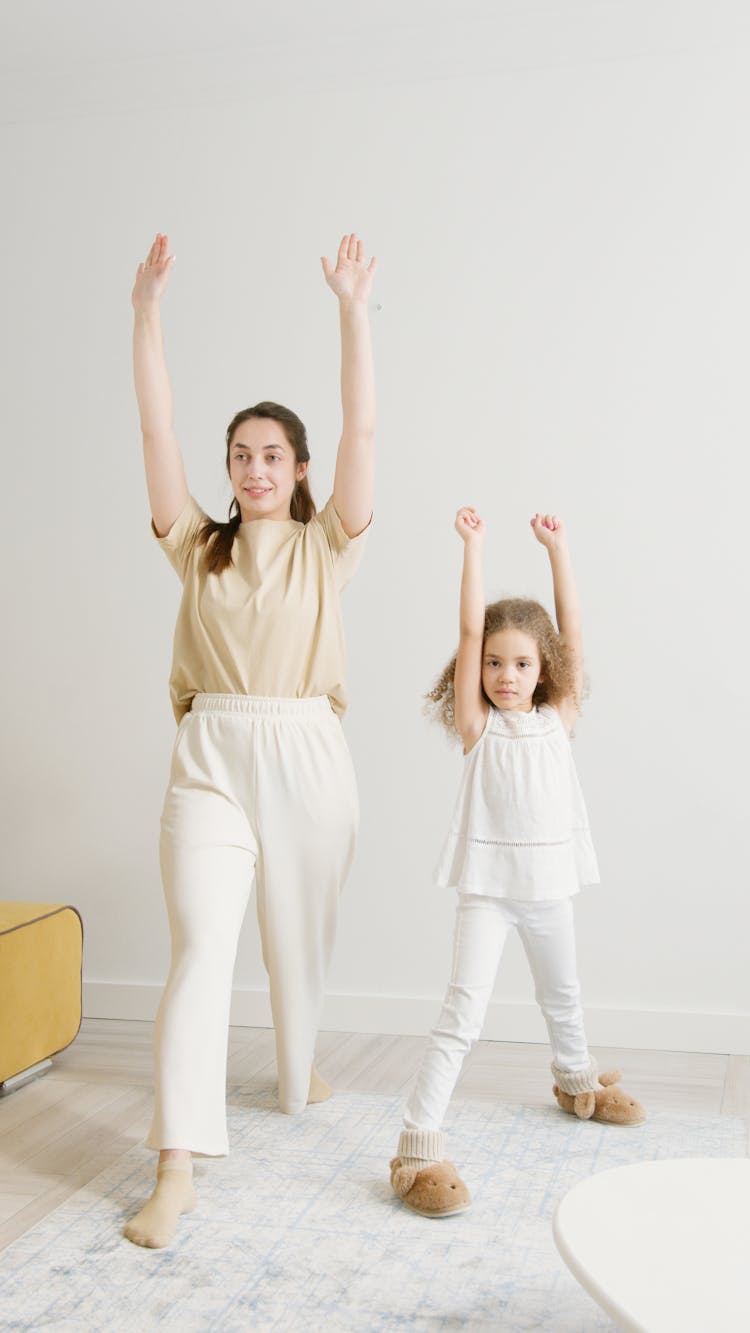 Woman And A Girl Exercising At Home