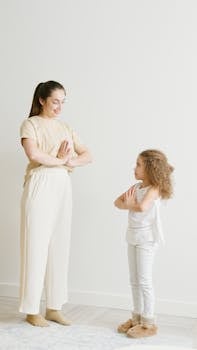 A mother and daughter practicing yoga together indoors, promoting a healthy and relaxed lifestyle.