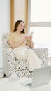 Woman Sitting on Sofa Using a Cellphone