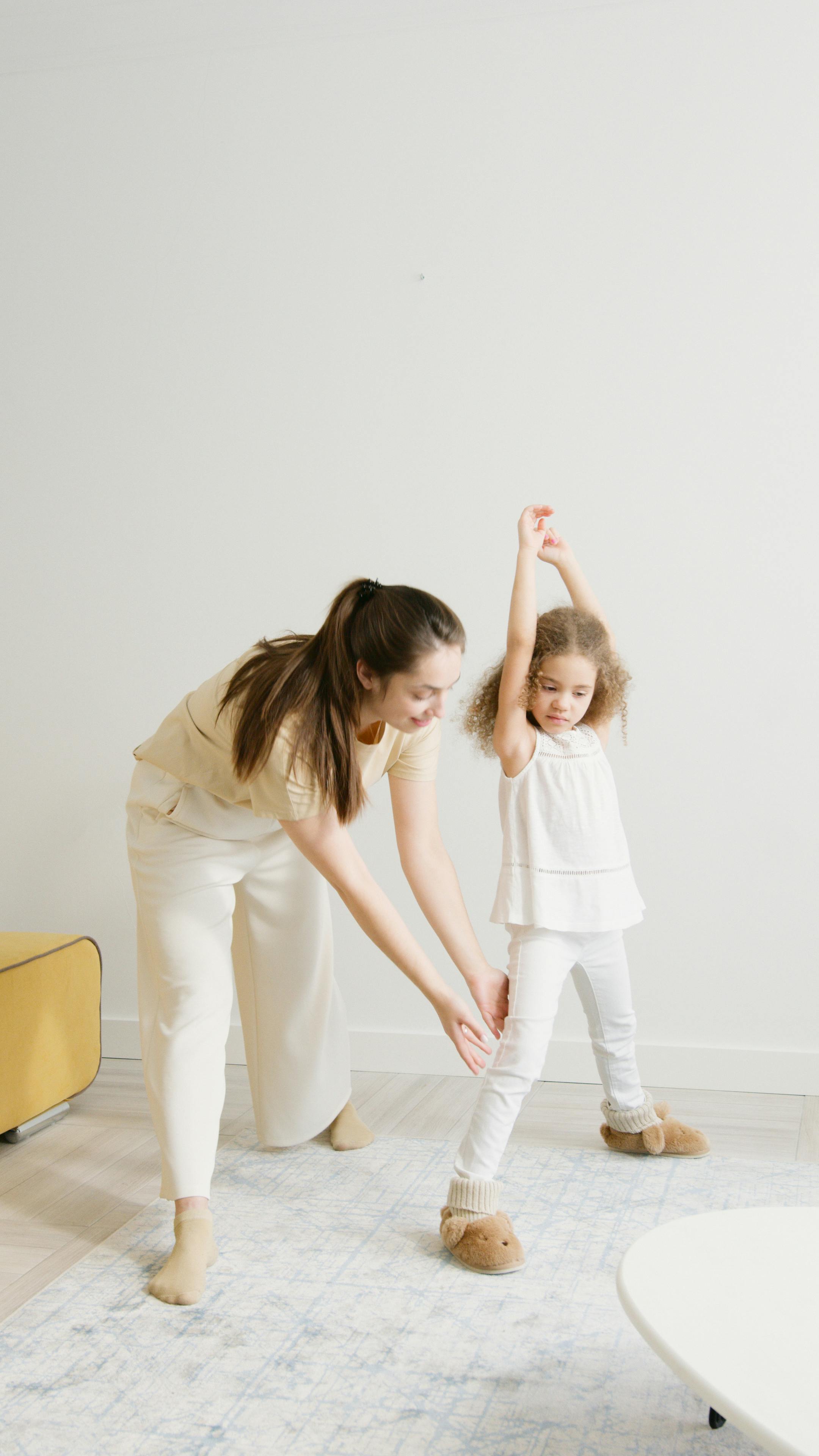 woman teaching a girl how to exercise