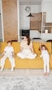 A Woman and Her Children Sitting on the Sofa