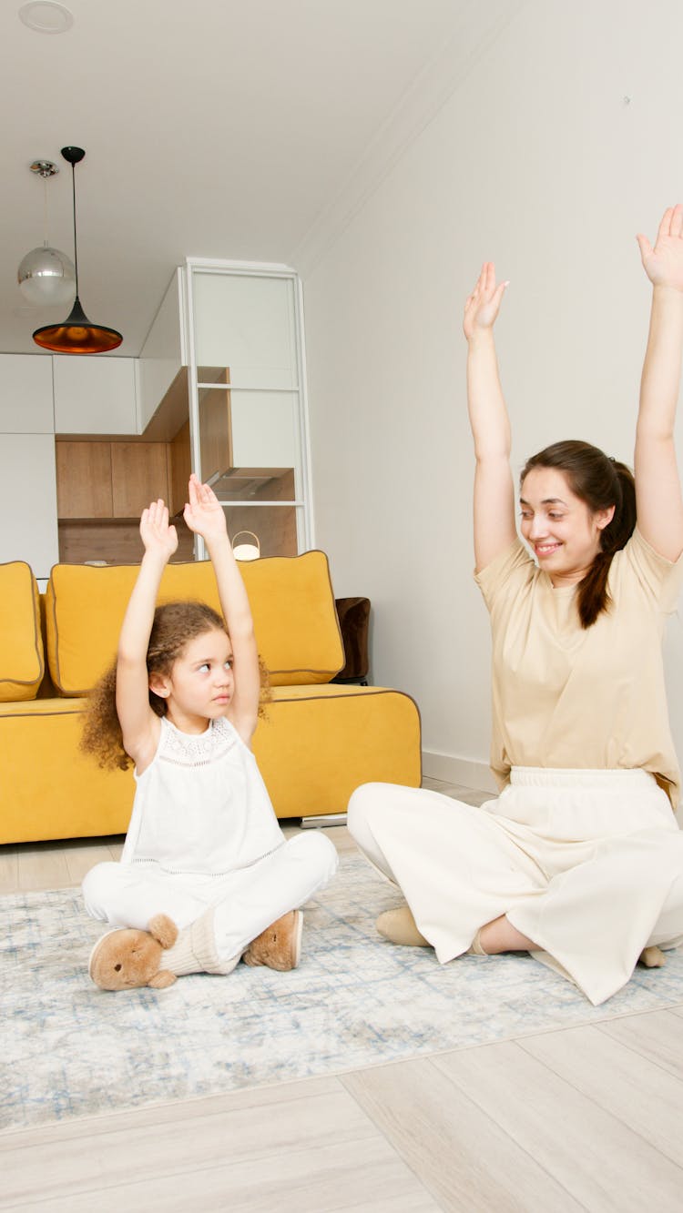 A Mother And Daughter Raising Their Hands