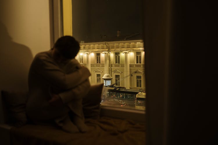 A Sad Woman Sitting Near The Window