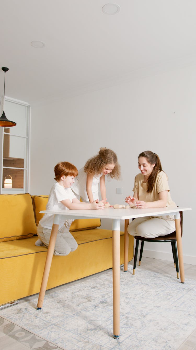 A Mother And Her Children Playing Together At Home 