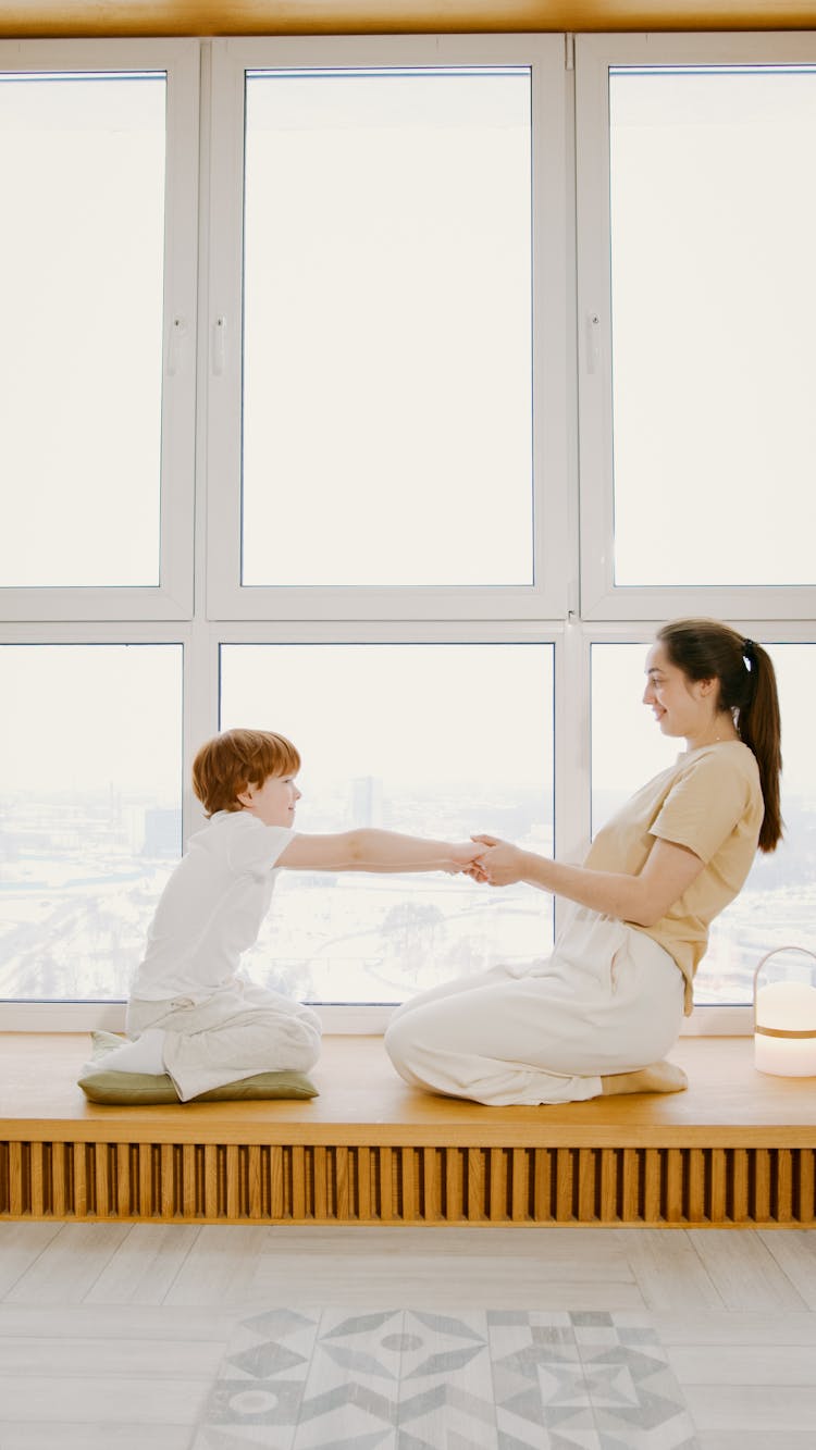 Woman And A Child Sitting While Pulling Each Other 