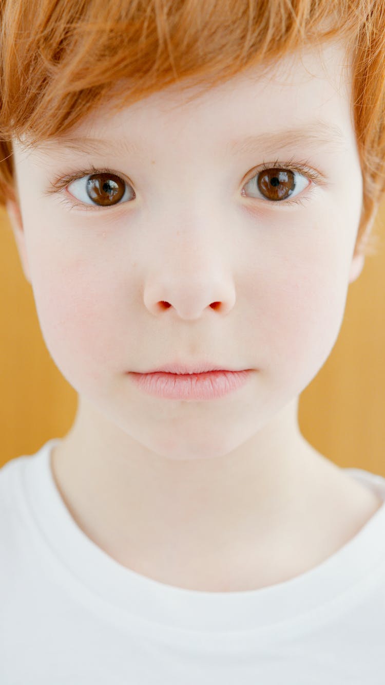Close-Up Shot Of A Boy In White Crew Neck Shirt
