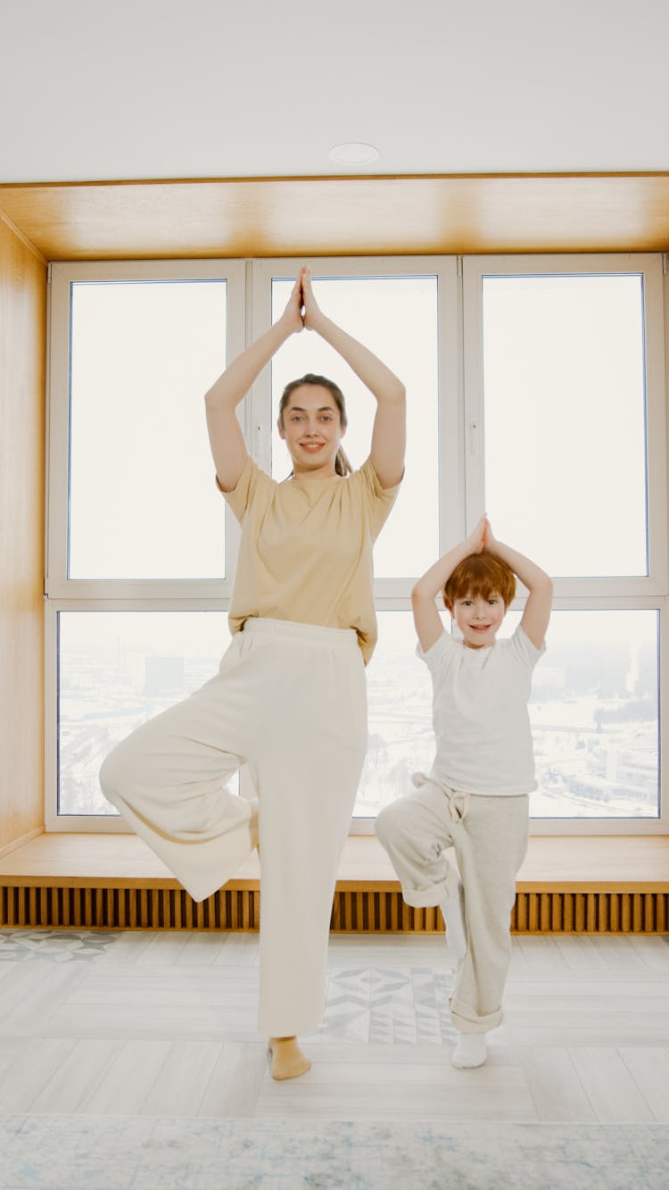 A Mother And Son Exercising At Home