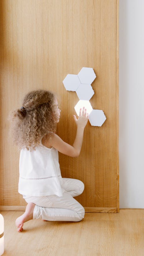 A Girl Touching the Light on the Wall