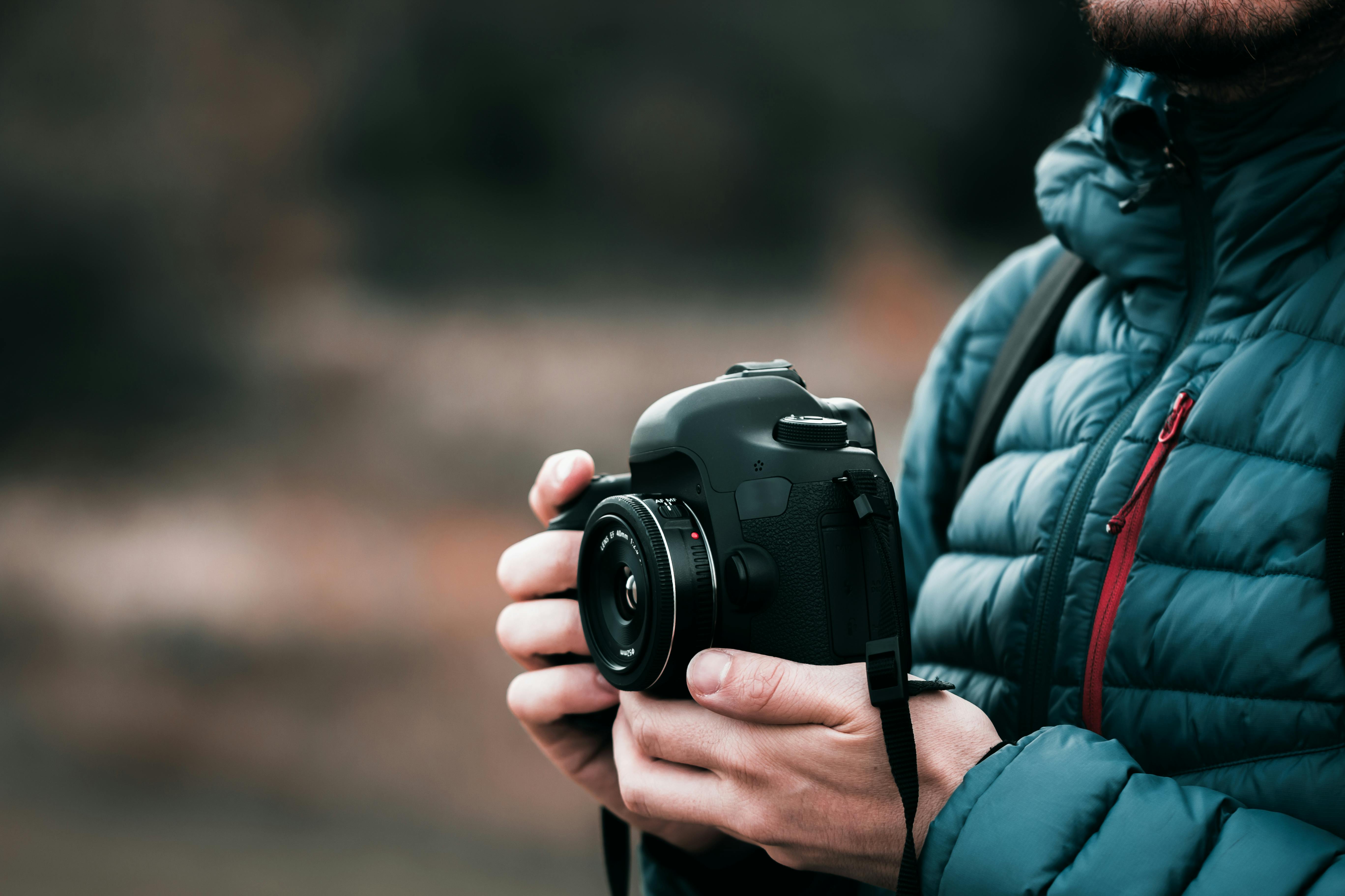 Person in White Dress Holding Grey and Black Camera on Grassland · Free ...