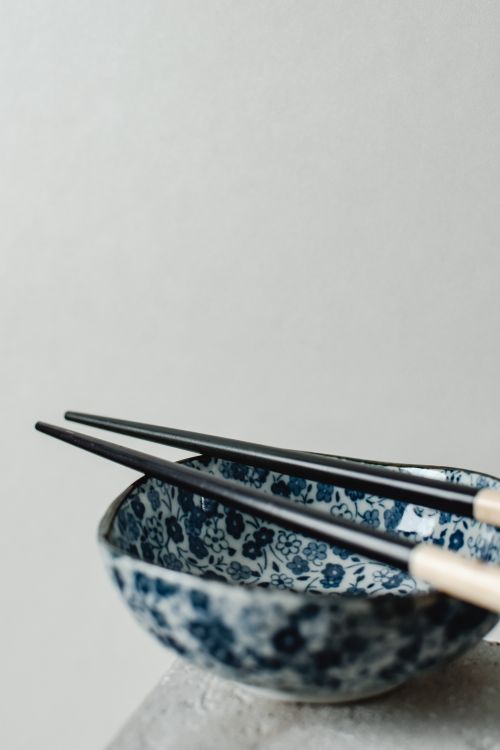 Free Close-up of a blue floral-patterned bowl with chopsticks, showcasing a minimalist and elegant style. Stock Photo