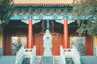 Gray Concrete Statue Near the Wooden Door